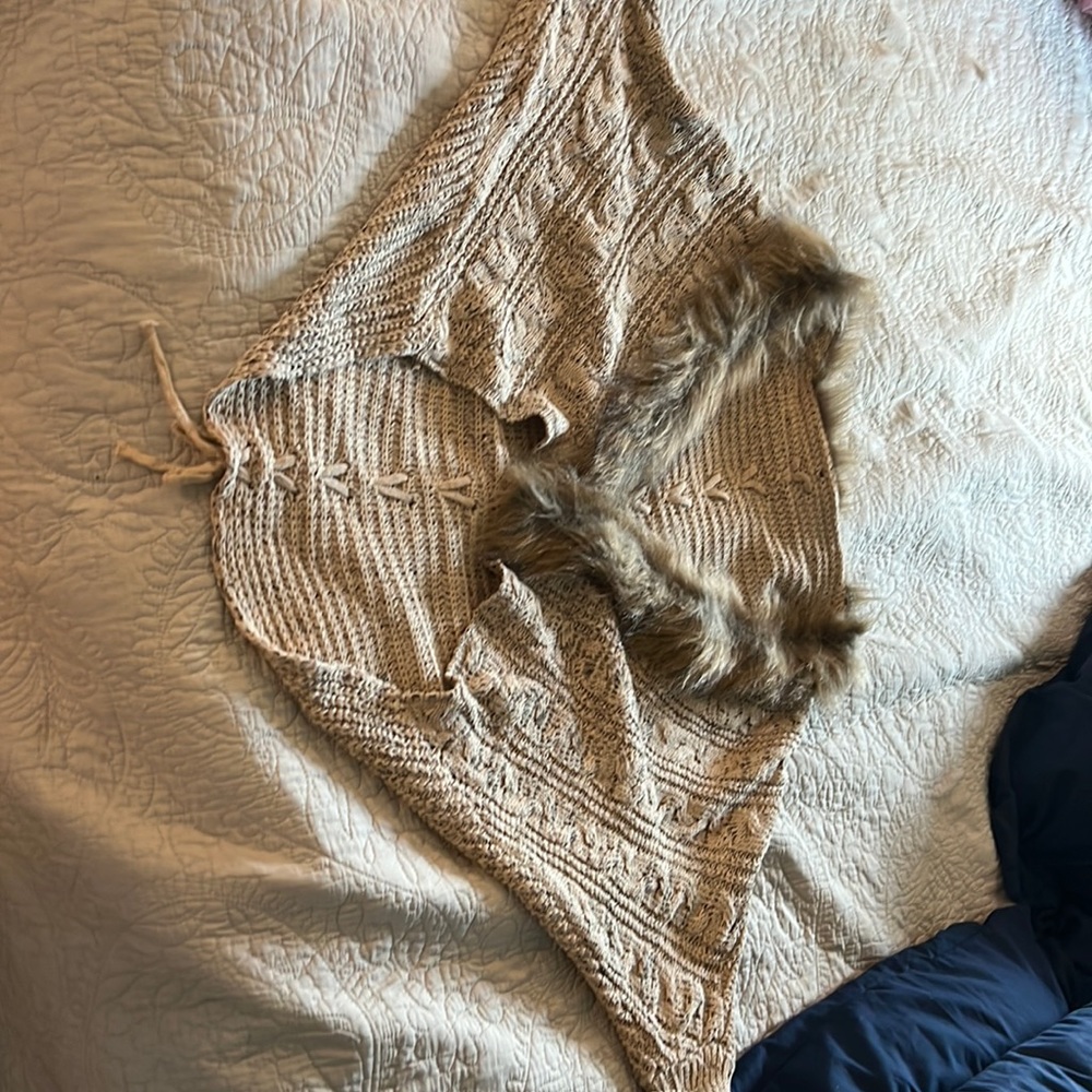 Bat winged, fur trimmed sweater with lacing detain down the back.